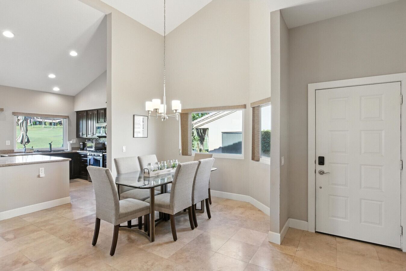 A spacious kitchen with a dining area, a large window, and a door.