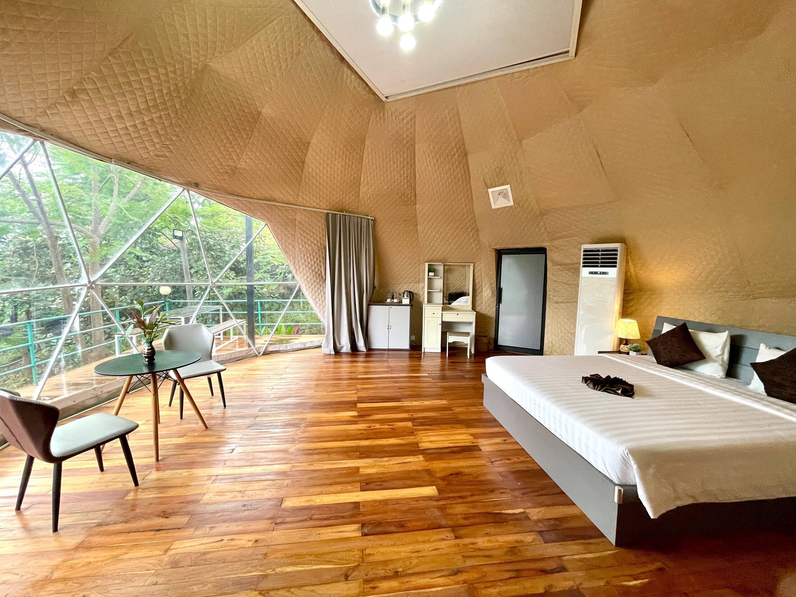 A room with a bed, a desk, a chair, and a table.