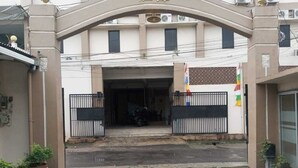 A gated entrance to a building with a large archway and a flag on the right side.