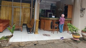 A hotel reception area with a counter, a wooden chair, and a reception desk.