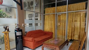 A living room with a red sofa, a wooden coffee table, and a glass partition.