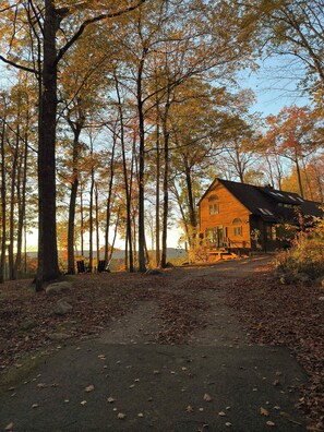A rustic cabin surrounded by tall trees with autumn foliage. - Hilltop Escape with Views & Hot Tub (New Marlborough)