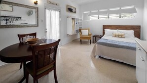 A bedroom with a bed, bedside table, and a window.