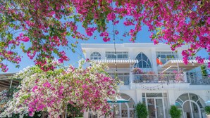 A hotel with a pool, outdoor seating, and a balcony with flowers. - Mia Hot Springs Pool Villa Binh Chau (Ho Chi Minh City)