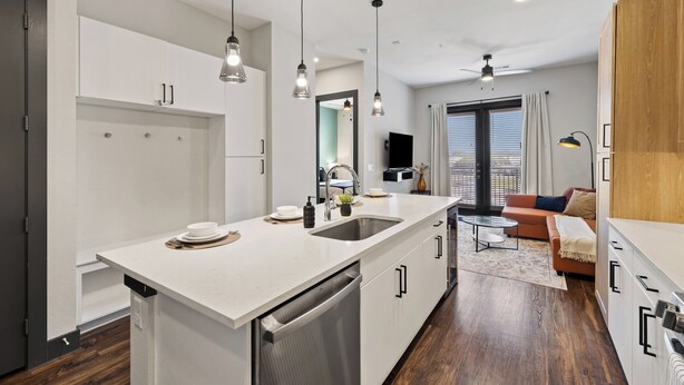 A modern kitchen with a large island, white cabinetry, and pendant lighting. - Luxury King Bed+Pool+Gym+DowntownATX+Domain+Q2Stadium (Austin)