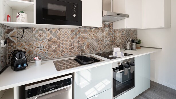 A modern kitchen with a built-in microwave, a dishwasher, and an oven.
