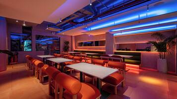 A modern restaurant with a bar area, seating arrangements, and a visible fire extinguisher.