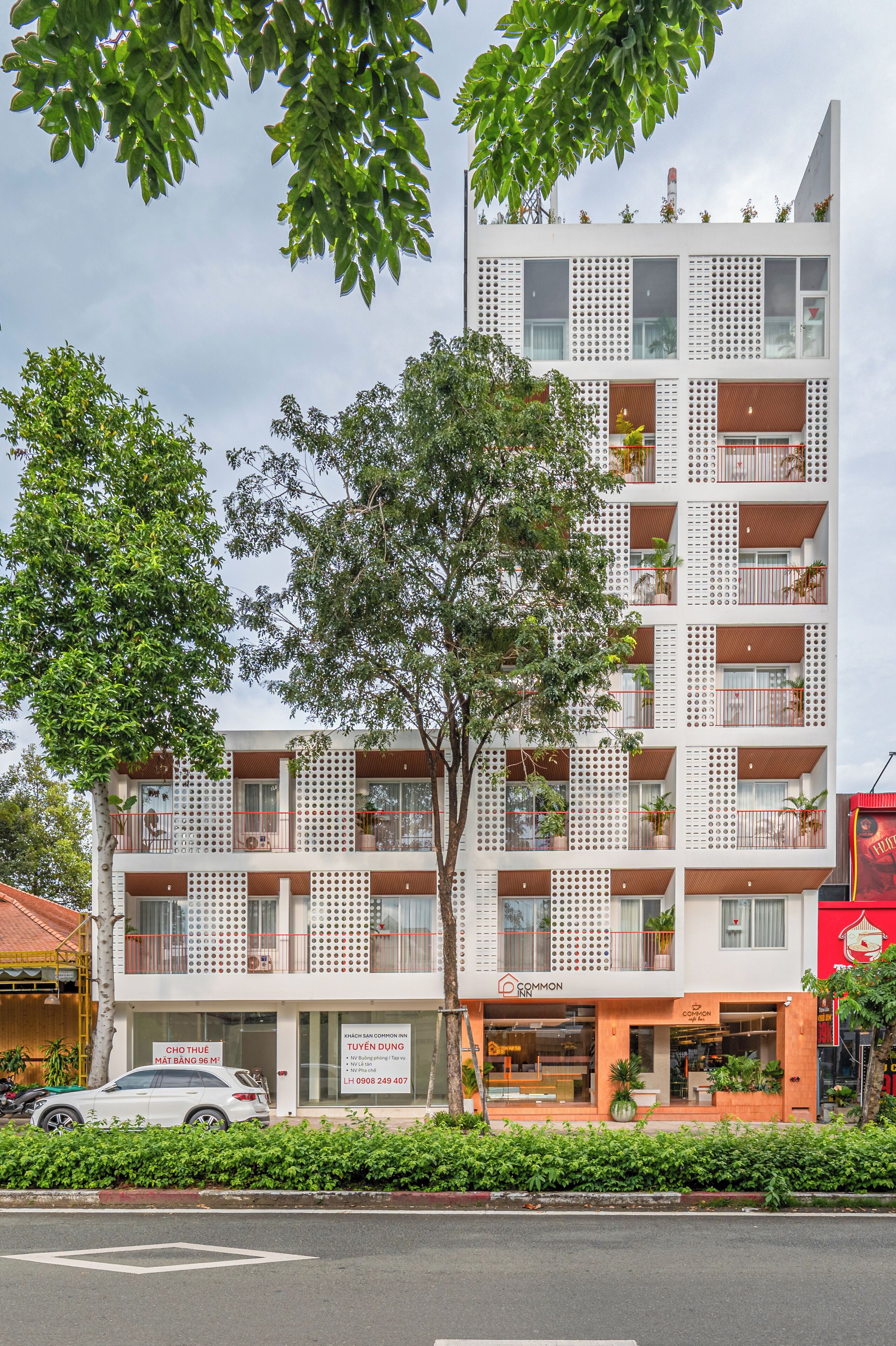 A multi-story building with balconies, a sign for 'CHO THUONG MAT BANG 96 M', and a 'COMMON' sign indicating a common area.