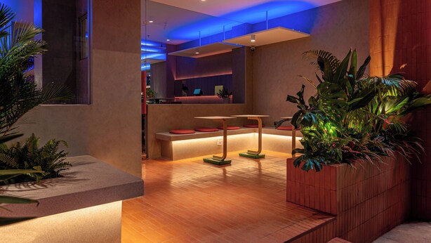 Un interno moderno con una reception, una zona salotto e pavimento in legno.