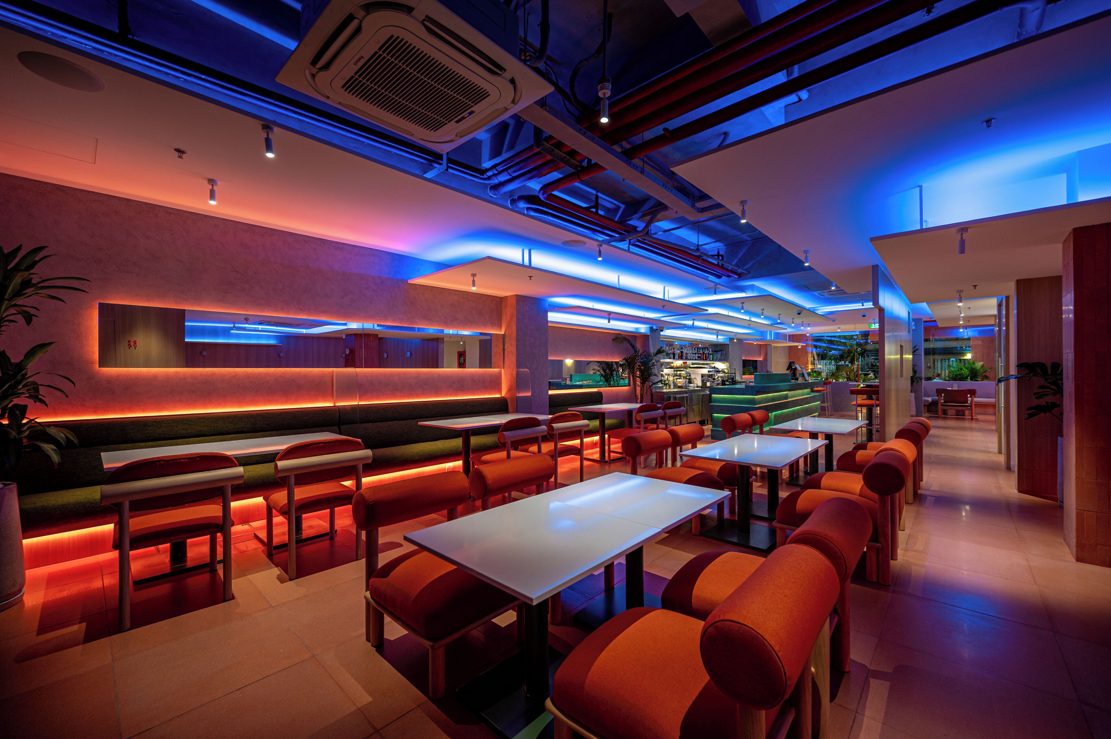A modern restaurant with a bar area, booths, and tables.