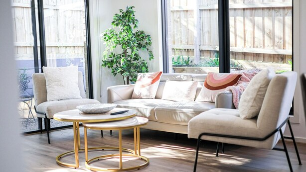 A modern living room with a beige sofa, a round gold-framed coffee table, and a potted plant. - StayAU Officer Newly 5BRM Homley Villa House (Officer)