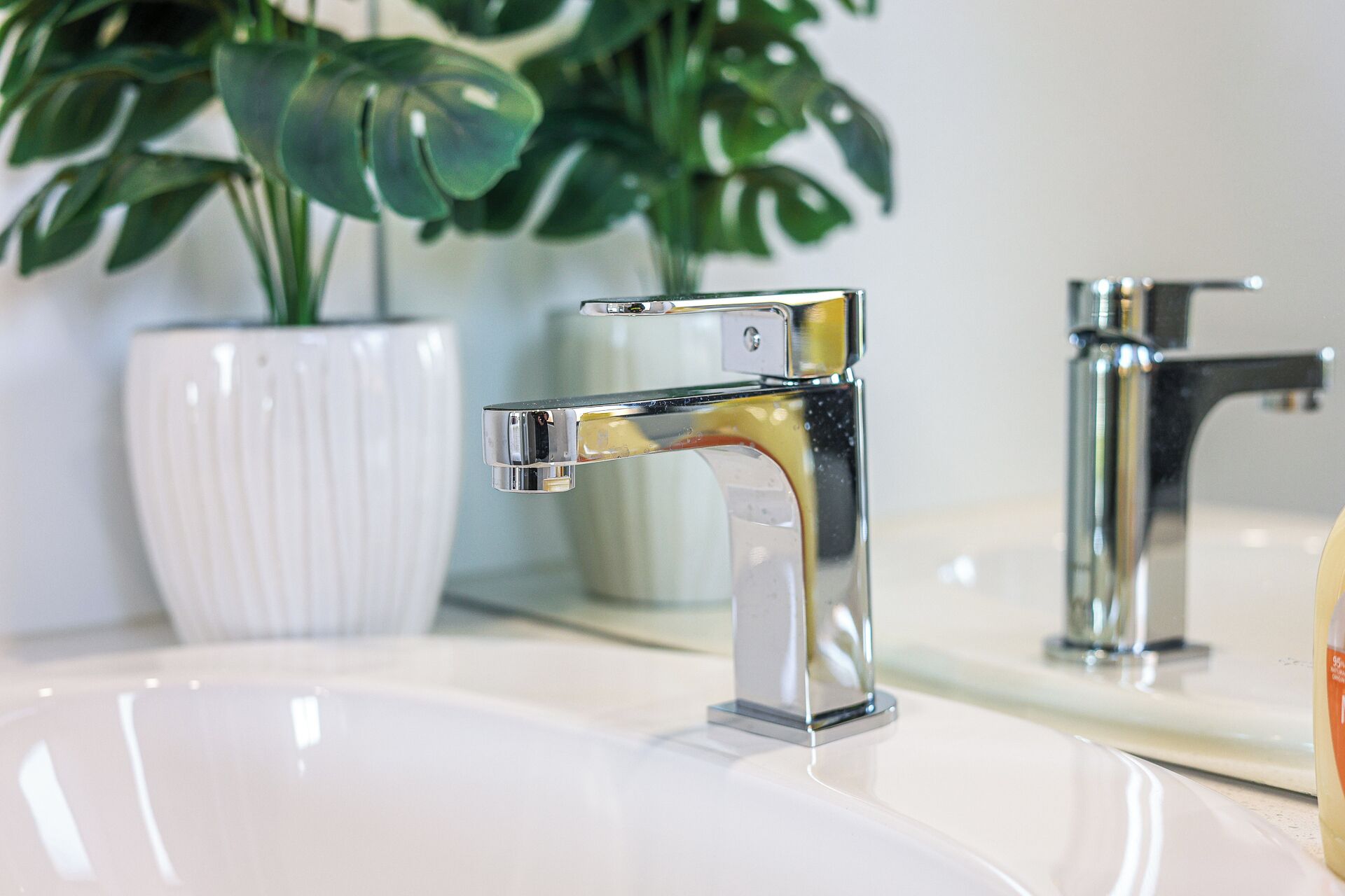 A modern bathroom with a chrome faucet and a white sink.