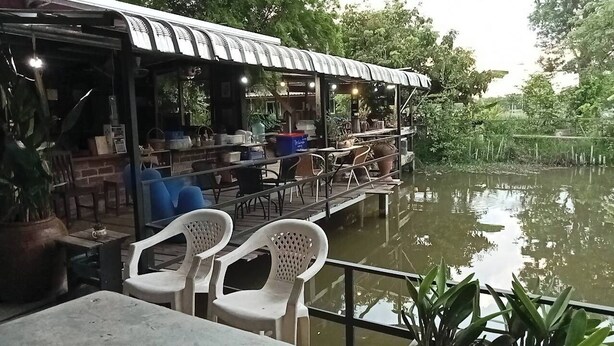 A riverside restaurant with outdoor seating and a covered dining area. - Ingna Resort (Chanuman)