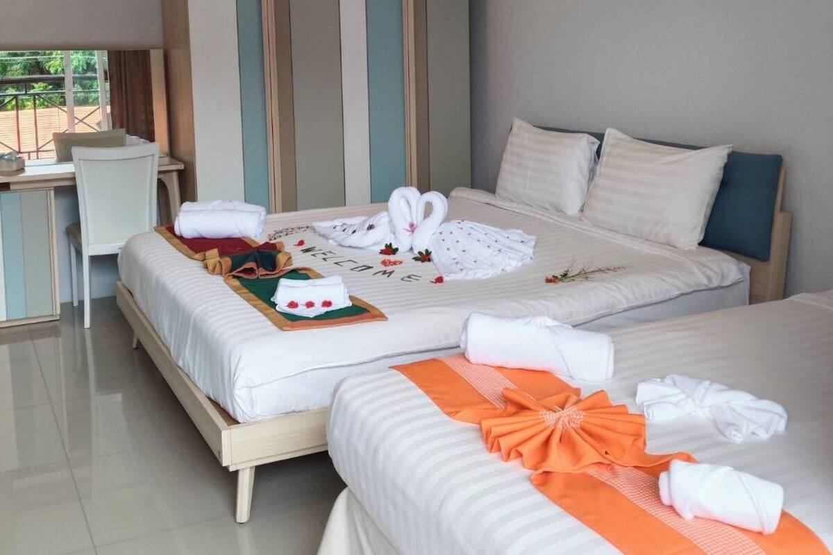Une chambre d’hôtel avec deux lits, un bureau et une armoire.