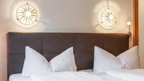A neatly made bed with white bedding and a brown upholstered headboard. - Apartment with wellness & Premium Card (Wildschönau)