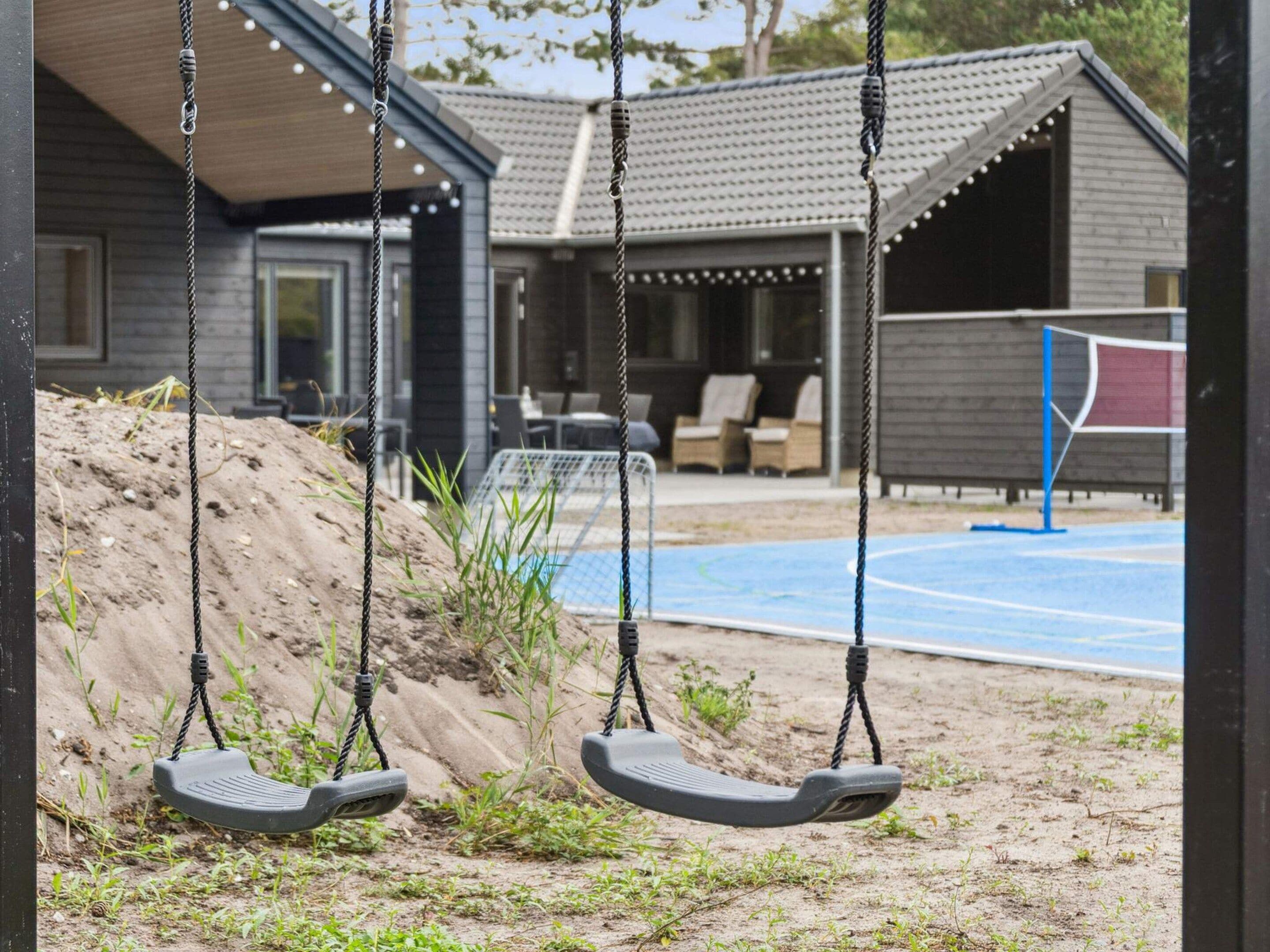 A playground with swings and a basketball court.