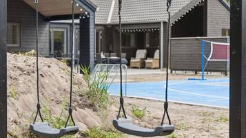 A playground with swings and a basketball court.
