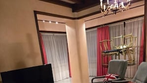 Een moderne woonkamer met een flatscreen televisie, een bijzondere salontafel en een comfortabele zithoek.