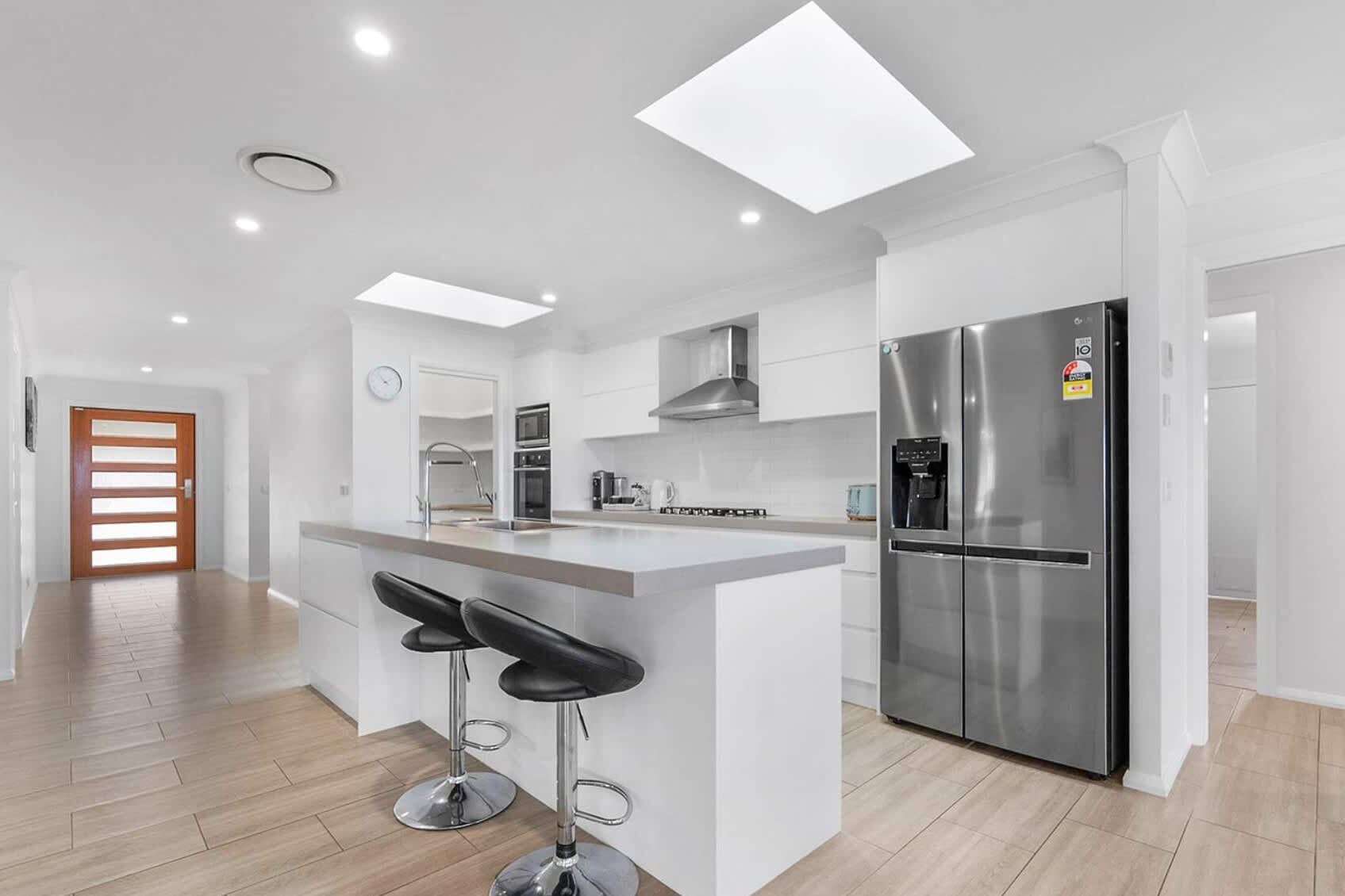 A modern kitchen with a central island, stainless steel appliances, and a minimalist design.