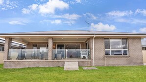 A two-story house with a covered porch, a brick exterior, and a small front yard. - Ignatius Retreat | Bathurst | Family Entertainer (Kelso)