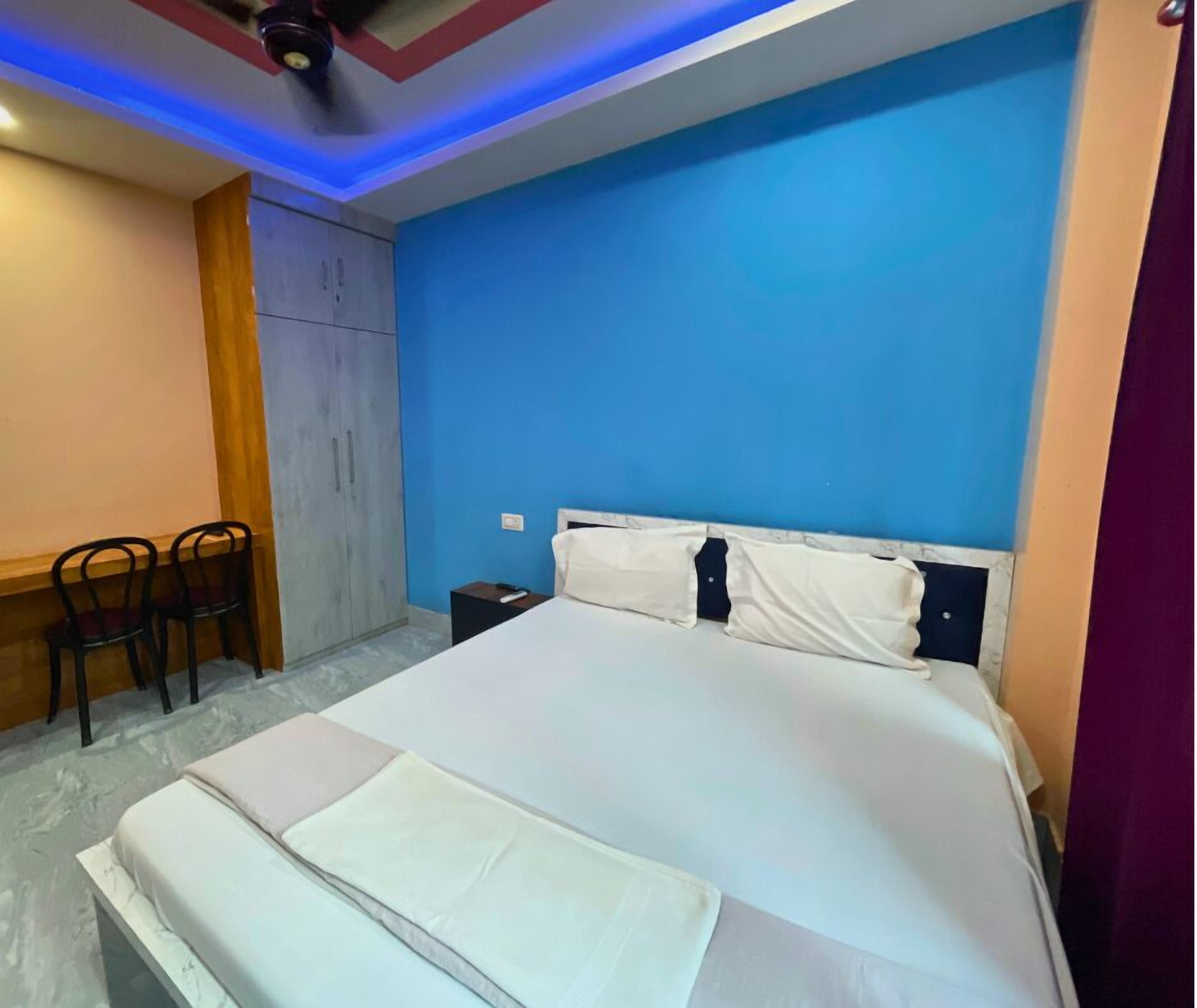 Une chambre à coucher avec un grand lit, un bureau avec des chaises et une armoire.