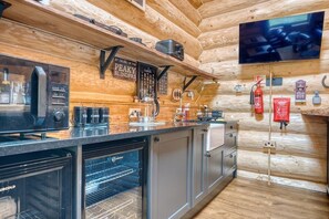 A modern kitchen with a built-in oven, coffee maker, and a sign reading "BY ORDER OF THE PEAKY BLINDFRS."