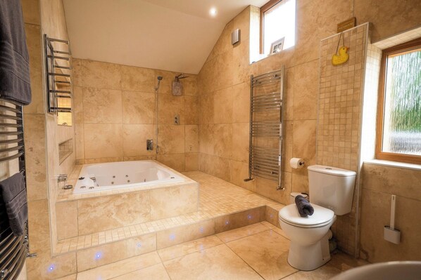 Un baño con bañera, inodoro y ducha.