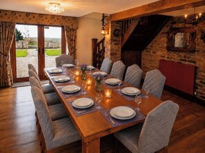 A dining room with a long wooden table set for six, surrounded by cushioned chairs. - Grand Country Estate 3 Hot Tubs Sleeps 16 near Durham City & Bishop Auckland (Oakenshaw)