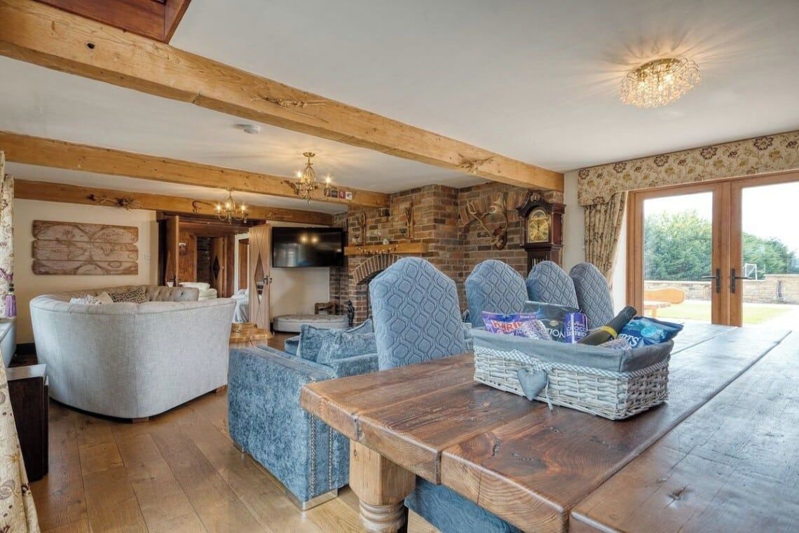 A cozy living room with a wooden table, cushioned seating, and a television.