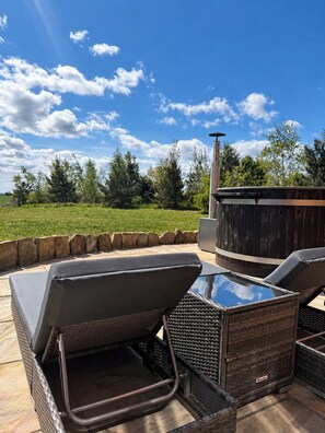 An outdoor seating area with a hot tub and a stone wall. - Grand Country Estate 3 Hot Tubs Sleeps 16 near Durham City & Bishop Auckland (Oakenshaw)
