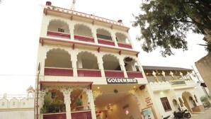 A hotel named 'Hotel Golden Bird' with a traditional architectural style, multiple balconies, and a sign indicating a swimming pool. - Hotel Golden Bird (Pushkar)