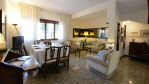 Un coin repas avec une table dressée pour quatre personnes, un canapé et un téléviseur dans le salon.