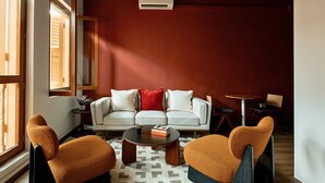 A modern living room with a sofa, two armchairs, a coffee table, and a small side table. - Hmlet Chinatown (Singapore)