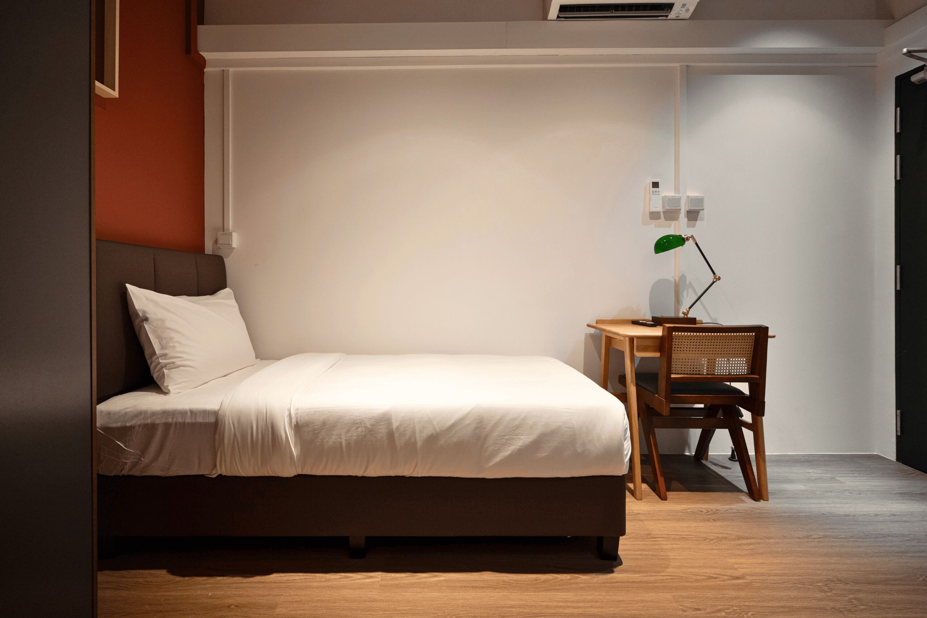 Un dormitorio con cama, escritorio y silla.