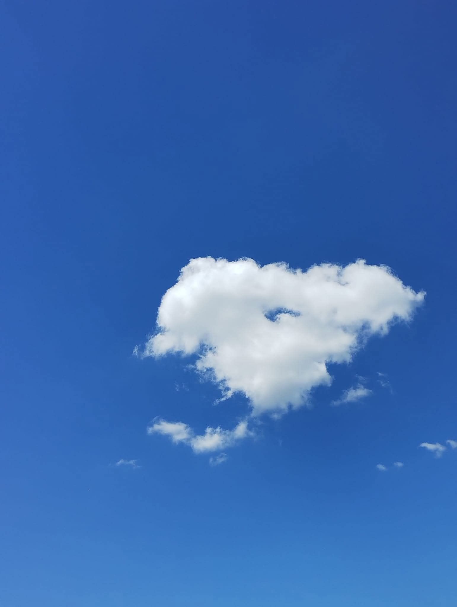 Ein klarer, blauer Himmel mit einer einzelnen, weißen Wolke.