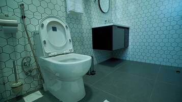 A bathroom with a toilet, a sink, and a shower.