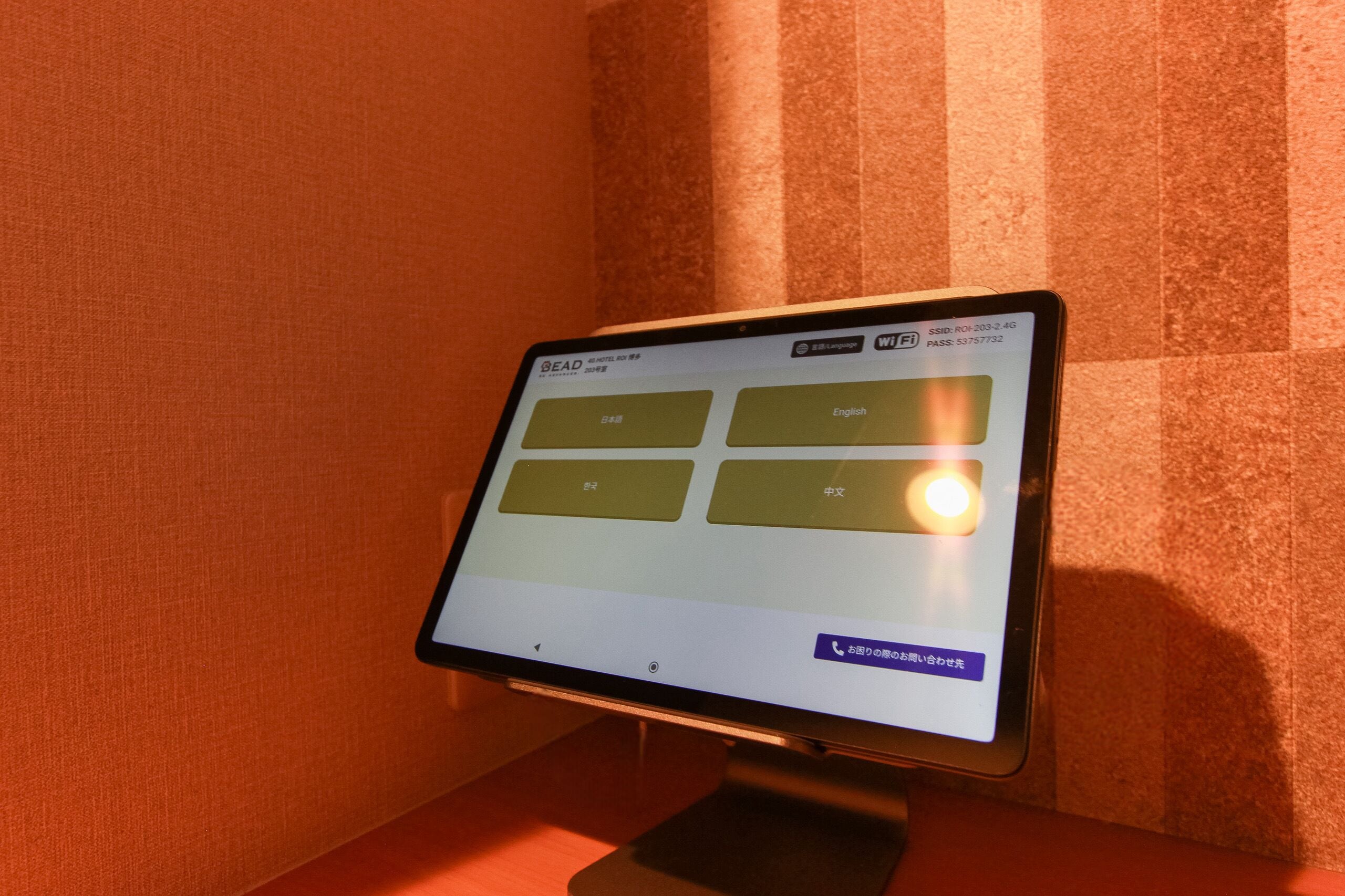 A hotel reception desk with a digital screen displaying room options and a WiFi symbol.