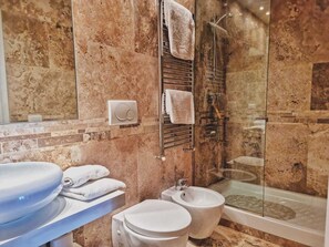 Een douche, een haardroger, een bidet, handdoeken