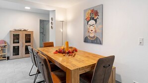 A dining area with a wooden table, chairs, and a painting on the wall. - Holiday Home 'Marina' with Private Terrace, Wi-Fi and Air Conditioning (Baden-Baden)