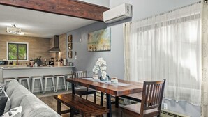 A modern kitchen with wooden cabinets, a built-in stove, and a window overlooking a garden.