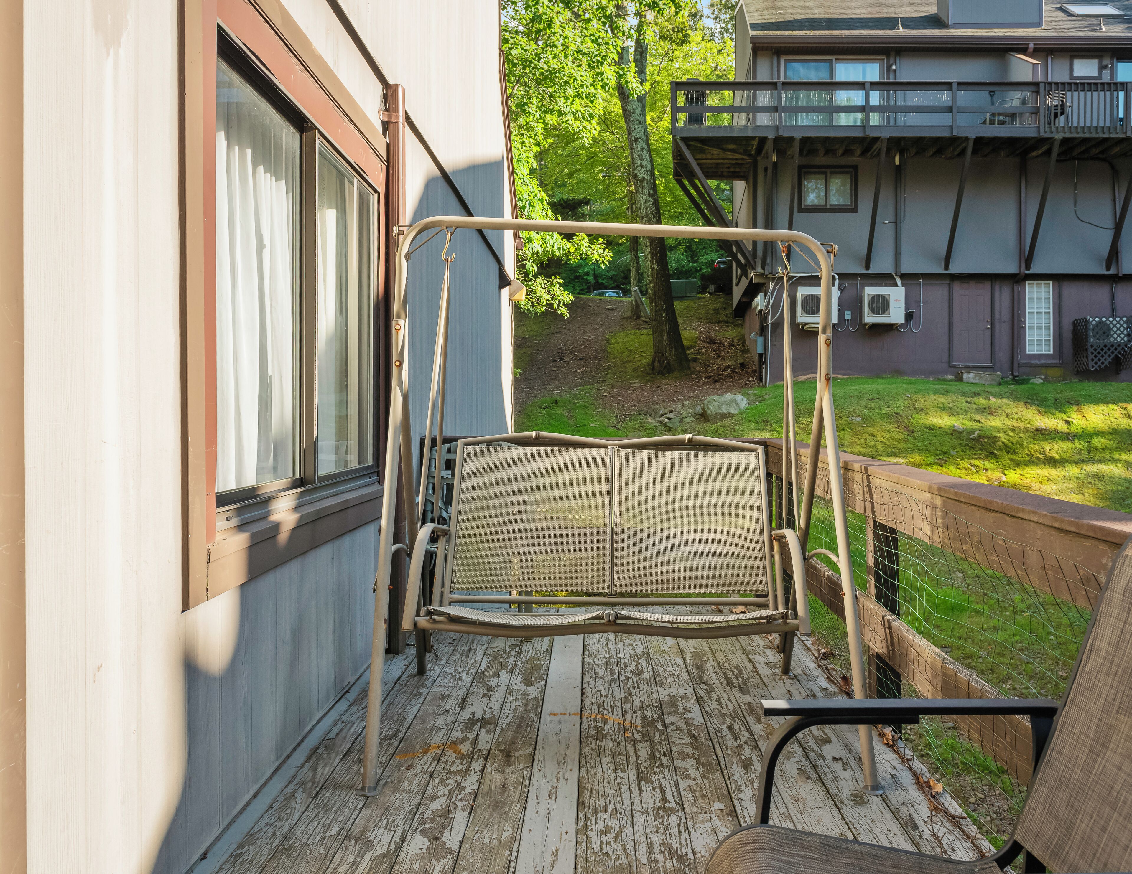 Een balkon met een metalen stoel en een hangmat.