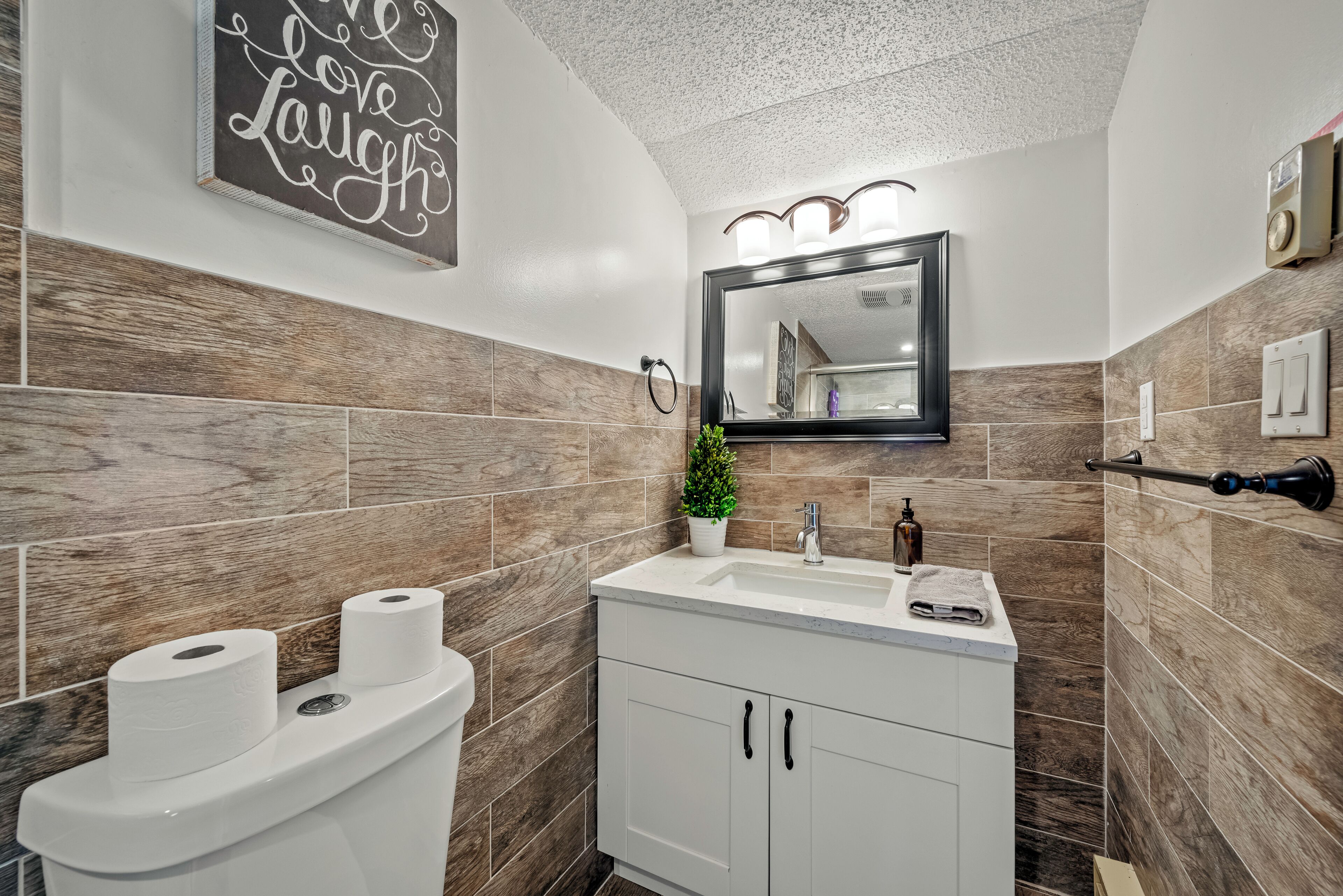 Une salle de bain moderne avec des toilettes, un lavabo et un miroir.