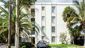 A multi-story building with a car parked in front.