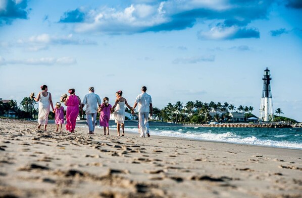 A beach scene with a lighthouse in the background.