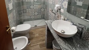 A bathroom with a shower, two toilets, a sink, and a mirror. - B&B CASA LAMANNA- Room No. 5 (Torretta)