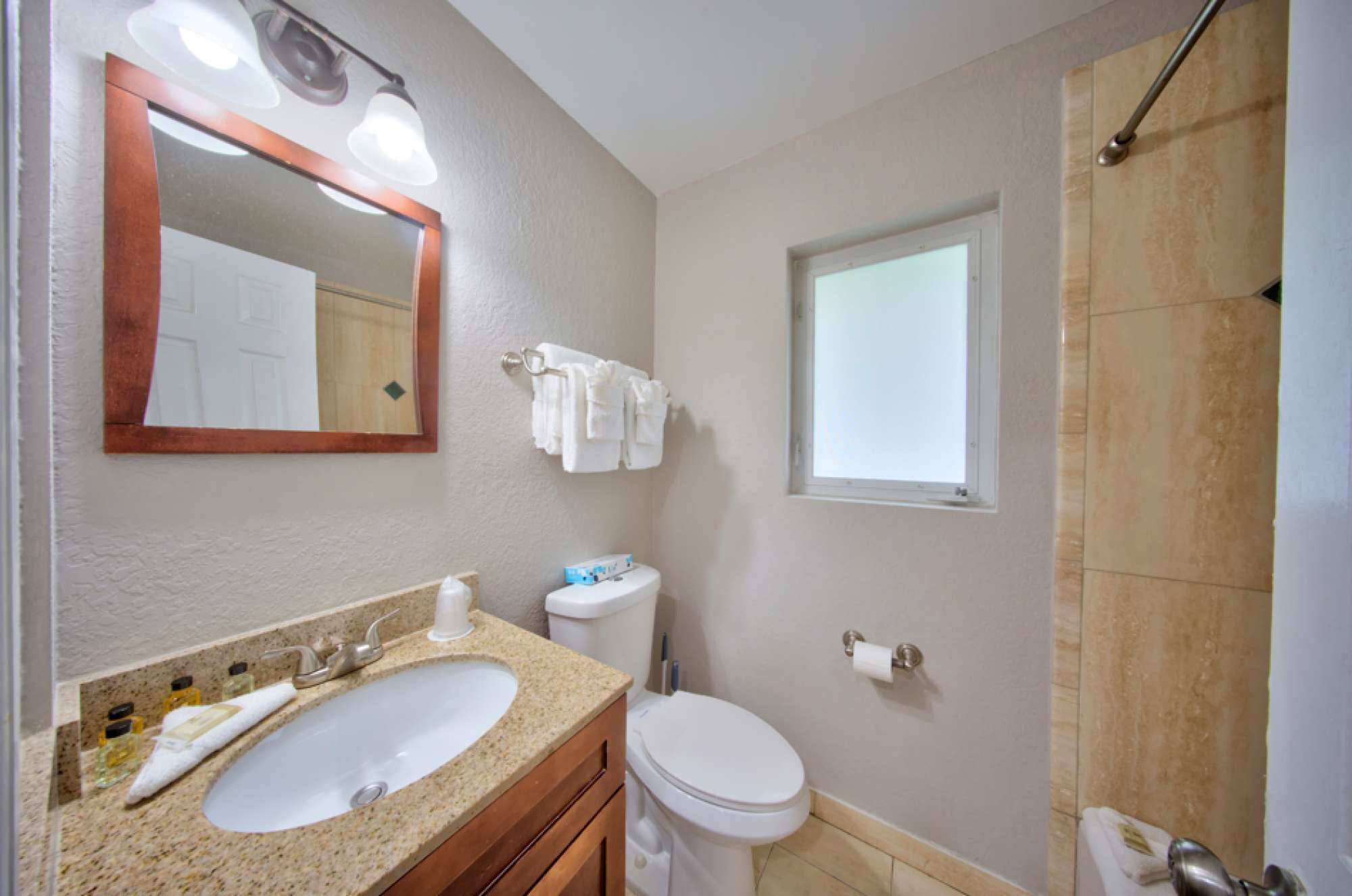 A bathroom with a sink, toilet, and shower.