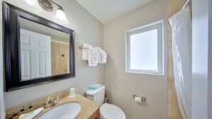 Ein Badezimmer mit Waschbecken, Toilette und Fenster.