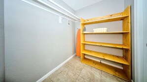 A narrow hallway with a wooden shelf unit against the wall, a radiator, and a door. - Sun Soaked in Paradise - King Studio W/ Pool (Pompano Beach)