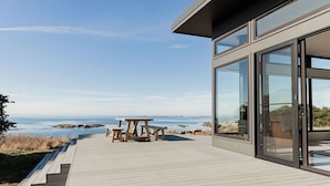Un edificio moderno con grandes ventanales que dan a una playa.