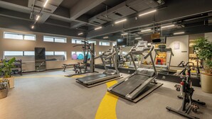 Un gimnasio con cintas de correr, elípticas y equipos de pesas.